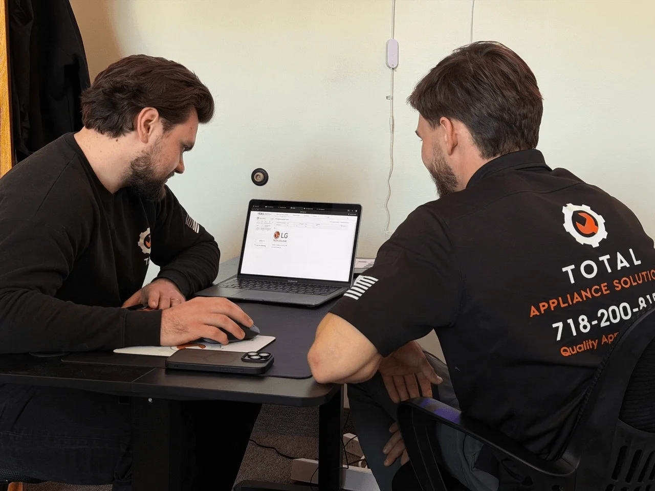 Two TAS technicians reviewing information on a laptop