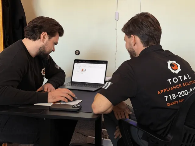 Two TAS technicians reviewing information on a laptop